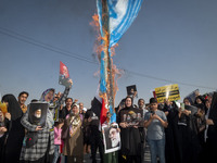 An Iranian man (not pictured) burns an Israeli flag while women hold portraits of Lebanon's Hezbollah Secretary General Hassan Nasrallah, fo...