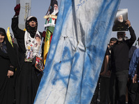 An Iranian man (not pictured) holds an Israeli flag while people hold portraits of Lebanon's Hezbollah Secretary General Hassan Nasrallah an...