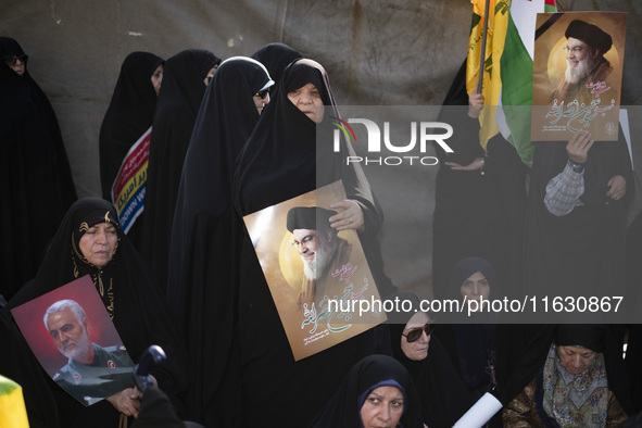 Veiled Iranian women hold portraits of Lebanon's Hezbollah Secretary General Hassan Nasrallah and former IRGC's Quds Force Commander, Genera...