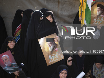 Veiled Iranian women hold portraits of Lebanon's Hezbollah Secretary General Hassan Nasrallah and former IRGC's Quds Force Commander, Genera...