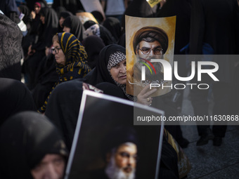 Veiled Iranian women hold portraits of Lebanon's Hezbollah Secretary General Hassan Nasrallah during a gathering marking the memory of Nasra...