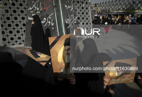 Veiled Iranian women hold portraits of Lebanon's Hezbollah Secretary General Hassan Nasrallah during a gathering marking the memory of Nasra...