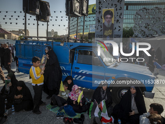 Veiled Iranian women sit under a portrait of Lebanon's Hezbollah Secretary General Hassan Nasrallah during a gathering marking the memory of...