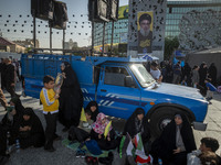 Veiled Iranian women sit under a portrait of Lebanon's Hezbollah Secretary General Hassan Nasrallah during a gathering marking the memory of...