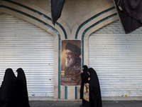 Veiled Iranian women walk past a portrait of Lebanon's Hezbollah Secretary General Hassan Nasrallah after a gathering marking the memory of...