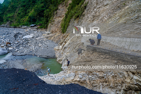 Due to heavy rainfall, the Kulekhani River flood damages the Dakshinkali-Sisneri road in Sisneri, Makwanpur, Nepal, on October 2, 2024. Peop...