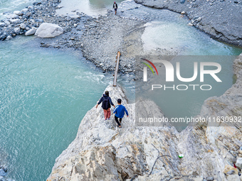 Due to heavy rainfall, the Kulekhani River flood damages the Dakshinkali-Sisneri road in Sisneri, Makwanpur, Nepal, on October 2, 2024. Peop...