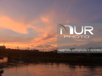 People and vehicles are seen as the sun sets in Siliguri, India, on October 2, 2024. (