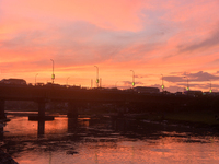 People and vehicles are seen as the sun sets in Siliguri, India, on October 2, 2024. (