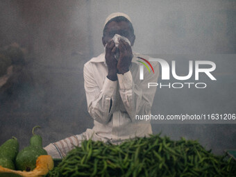 A man suffers in the smoke of mosquito repellent spray in Dhaka, Bangladesh, on October 2, 2024. (