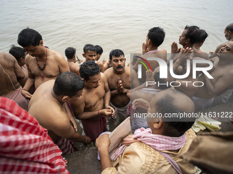 Hindu devotees perform the 'Tarpan' ritual during Mahalaya prayers, also known as Pitru Paksha, at the Brahmaputra river, in Guwahati, India...