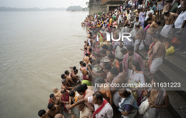 Hindu devotees perform the 'Tarpan' ritual during Mahalaya prayers, also known as Pitru Paksha, at the Brahmaputra river, in Guwahati, India...