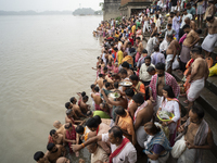 Hindu devotees perform the 'Tarpan' ritual during Mahalaya prayers, also known as Pitru Paksha, at the Brahmaputra river, in Guwahati, India...