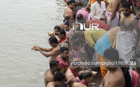 Hindu devotees perform the 'Tarpan' ritual during Mahalaya prayers, also known as Pitru Paksha, at the Brahmaputra river, in Guwahati, India...