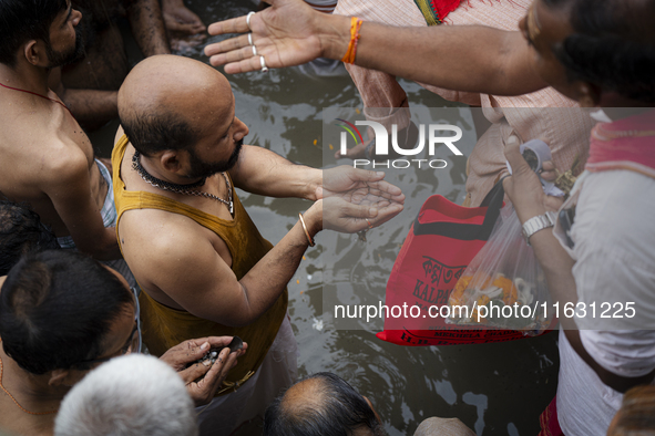 Hindu devotees perform the 'Tarpan' ritual during Mahalaya prayers, also known as Pitru Paksha, at the Brahmaputra river, in Guwahati, India...