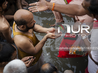 Hindu devotees perform the 'Tarpan' ritual during Mahalaya prayers, also known as Pitru Paksha, at the Brahmaputra river, in Guwahati, India...