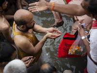 Hindu devotees perform the 'Tarpan' ritual during Mahalaya prayers, also known as Pitru Paksha, at the Brahmaputra river, in Guwahati, India...