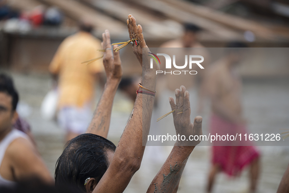 Hindu devotees perform the 'Tarpan' ritual during Mahalaya prayers, also known as Pitru Paksha, at the Brahmaputra river, in Guwahati, India...