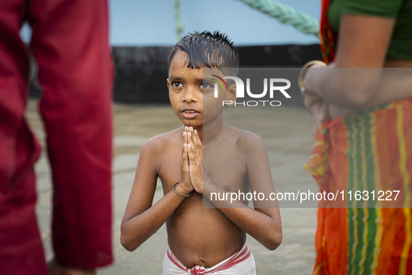 A child performs the 'Tarpan' ritual during Mahalaya prayers, also known as Pitru Paksha, at the Brahmaputra River in Guwahati, India, on Oc...