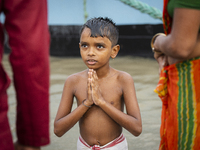 A child performs the 'Tarpan' ritual during Mahalaya prayers, also known as Pitru Paksha, at the Brahmaputra River in Guwahati, India, on Oc...