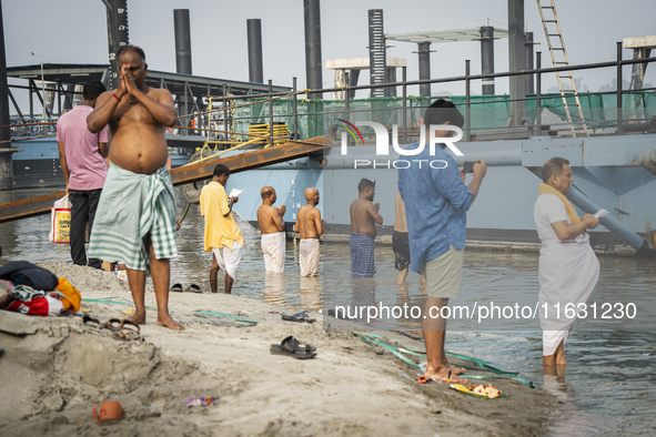 Hindu devotees perform the 'Tarpan' ritual during Mahalaya prayers, also known as Pitru Paksha, at the Brahmaputra river, in Guwahati, India...