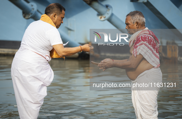 Hindu devotees perform the 'Tarpan' ritual during Mahalaya prayers, also known as Pitru Paksha, at the Brahmaputra river, in Guwahati, India...