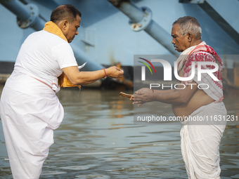 Hindu devotees perform the 'Tarpan' ritual during Mahalaya prayers, also known as Pitru Paksha, at the Brahmaputra river, in Guwahati, India...