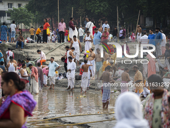 Hindu devotees perform the 'Tarpan' ritual during Mahalaya prayers, also known as Pitru Paksha, at the Brahmaputra river, in Guwahati, India...