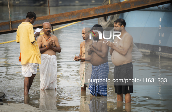 Hindu devotees perform the 'Tarpan' ritual during Mahalaya prayers, also known as Pitru Paksha, at the Brahmaputra river, in Guwahati, India...