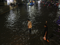 Residents walk through a waterlogged street following heavy rainfall in Dhaka, Bangladesh, on October 2, 2024. Several roads in the capital...