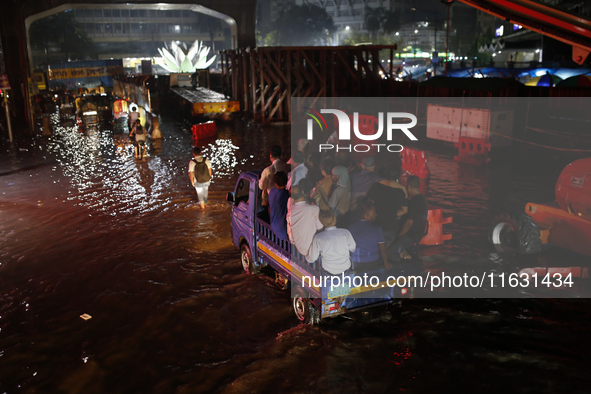 Residents make their way through a waterlogged street following heavy rainfall in Dhaka, Bangladesh, on October 2, 2024. Several roads in th...