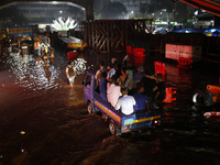 Residents make their way through a waterlogged street following heavy rainfall in Dhaka, Bangladesh, on October 2, 2024. Several roads in th...