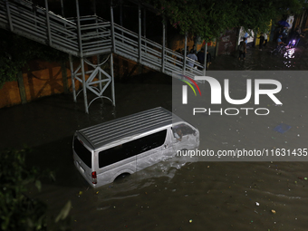 A vehicle is stuck on a waterlogged street following heavy rainfall in Dhaka, Bangladesh, on October 2, 2024. Several roads in the capital c...