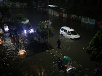 Residents make their way through a waterlogged street following heavy rainfall in Dhaka, Bangladesh, on October 2, 2024. Several roads in th...