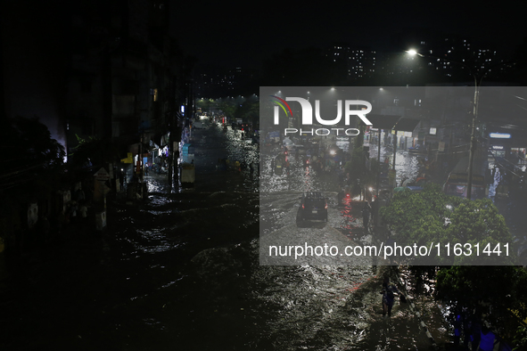 Residents make their way through a waterlogged street following heavy rainfall in Dhaka, Bangladesh, on October 2, 2024. Several roads in th...