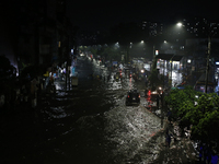 Residents make their way through a waterlogged street following heavy rainfall in Dhaka, Bangladesh, on October 2, 2024. Several roads in th...