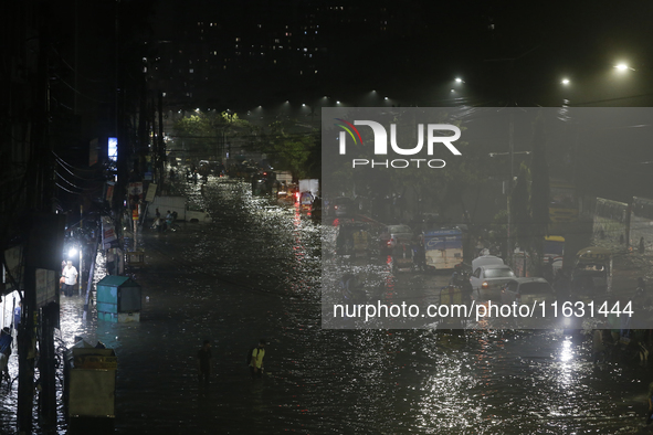 Residents make their way through a waterlogged street following heavy rainfall in Dhaka, Bangladesh, on October 2, 2024. Several roads in th...