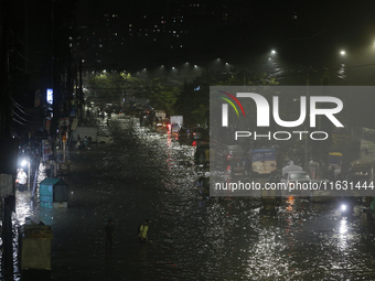 Residents make their way through a waterlogged street following heavy rainfall in Dhaka, Bangladesh, on October 2, 2024. Several roads in th...