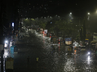 Residents make their way through a waterlogged street following heavy rainfall in Dhaka, Bangladesh, on October 2, 2024. Several roads in th...