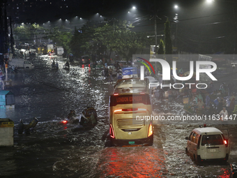 Residents make their way through a waterlogged street following heavy rainfall in Dhaka, Bangladesh, on October 2, 2024. Several roads in th...