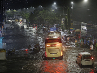 Residents make their way through a waterlogged street following heavy rainfall in Dhaka, Bangladesh, on October 2, 2024. Several roads in th...