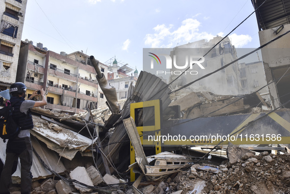 Smoke rises from a building destroyed by an Israeli airstrike as journalists and local residents visit during a press tour in Beirut, Lebano...