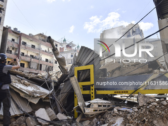 Smoke rises from a building destroyed by an Israeli airstrike as journalists and local residents visit during a press tour in Beirut, Lebano...