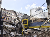 Smoke rises from a building destroyed by an Israeli airstrike as journalists and local residents visit during a press tour in Beirut, Lebano...