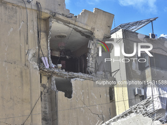 Smoke rises from a building destroyed by an Israeli airstrike as journalists and local residents visit during a press tour in Beirut, Lebano...