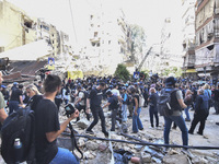 Smoke rises from a building destroyed by an Israeli airstrike as journalists and local residents visit during a press tour in Beirut, Lebano...