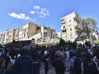 Smoke rises from a building destroyed by an Israeli airstrike as journalists and local residents visit during a press tour in Beirut, Lebano...