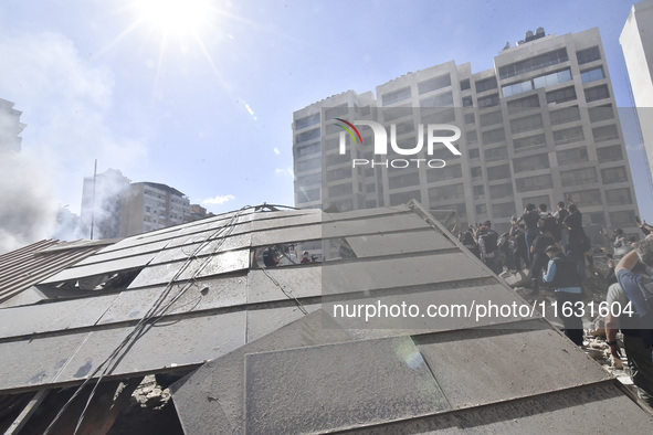 Smoke rises from a building destroyed by an Israeli airstrike as journalists and local residents visit during a press tour in Beirut, Lebano...