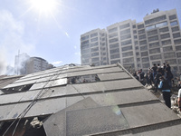 Smoke rises from a building destroyed by an Israeli airstrike as journalists and local residents visit during a press tour in Beirut, Lebano...