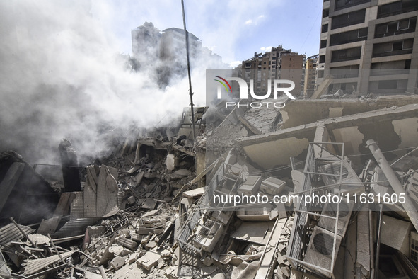 Smoke rises from a building destroyed by an Israeli airstrike as journalists and local residents visit during a press tour in Beirut, Lebano...